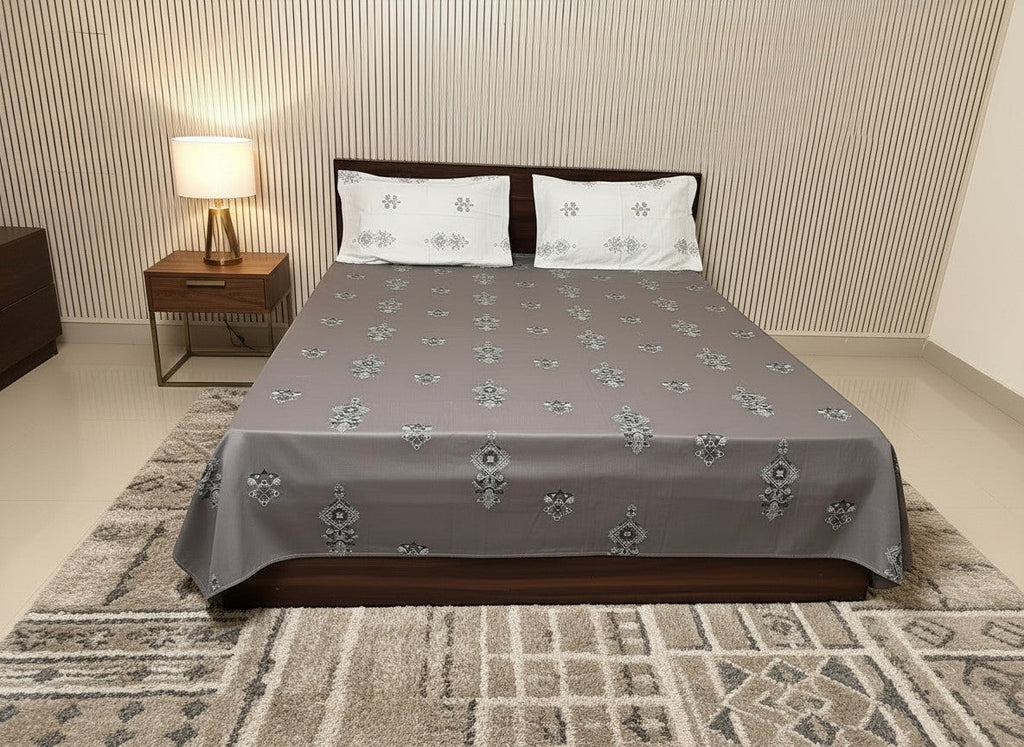 AthSVi Alayam grey cotton bed sheet set with traditional white and charcoal floral motifs and matching pillowcases.