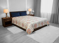 AthSVi Alayam king size cotton comforter with multicolour Jaipuri medallion block print on a white base on a bed